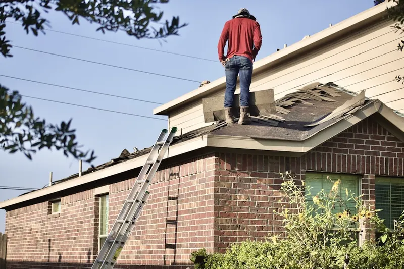 Professional roofer working on a residential roof in Whitesville